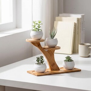 May include: A tiered bamboo plant stand with a natural wood finish, featuring four circular platforms at varying heights. Four small, white, ribbed ceramic pots are placed on the stand, each containing a different green succulent plant.