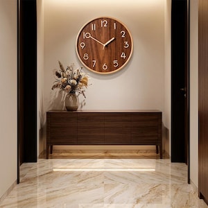 May include: A round wall clock with a dark brown wood grain face, a light wood frame, and raised white numerals. The clock features two simple white hands and is mounted on a wall above a dark wood sideboard with four cabinet doors.