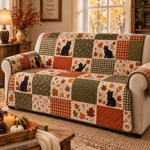 Puede incluir: Una funda de sofá acolchada con un diseño de patchwork de hojas de otoño, patrones de cuadros verdes y naranjas, y siluetas de gatos negros. La tela tiene una textura pespunteada y cubre el asiento, el respaldo y los brazos del sofá.