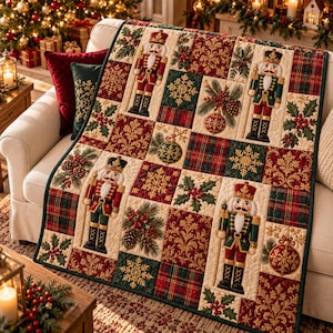 May include: A quilted throw blanket featuring a patchwork design of nutcracker figures, gold snowflakes, red and green plaid squares, holly berries, and ornate gold scrollwork patterns on a cream, red, and dark green fabric background.