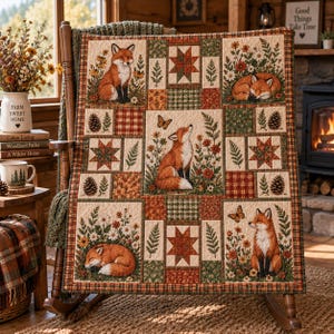 Puede incluir: Una colcha de patchwork con un patrón repetitivo de zorros, mariposas, piñas y motivos florales en tonos naranja, verde y crema. El diseño incluye bloques en forma de estrella y cuadrados a cuadros, con zorros representados sentados o durmiendo.