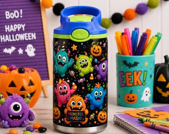 May include: A cylindrical water bottle with a black background featuring a colourful pattern of various cartoon monsters, pumpkins, and candy. The bottle has a blue lid with a green push-button release. One monster holds a sign that reads MONSTER MASH!