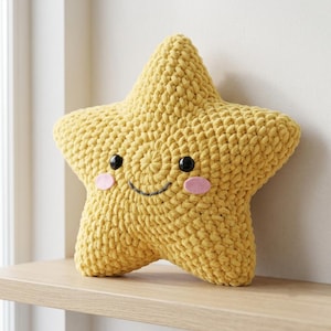 Peut inclure: Un coussin en crochet en forme d'étoile fait de fil jaune vif. Le coussin présente deux yeux ronds en plastique noir, une bouche incurvée brodée gris foncé et deux petites pièces ovales en feutrine rose sur les joues formant un visage souriant.