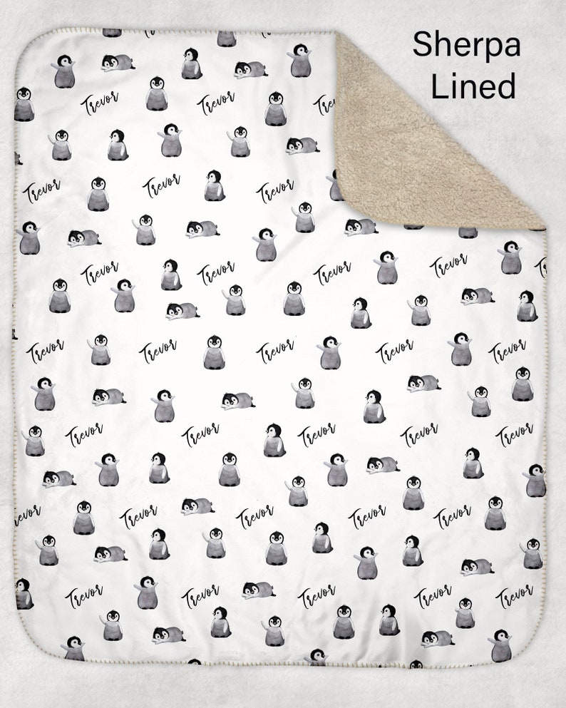 May include: White baby blanket with a repeating pattern of penguins and the name "Trevor" printed on it. The blanket is sherpa lined.