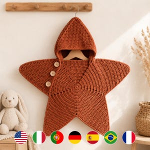 Könnte beinhalten: Eine sternförmige Kapuzendecke aus rostfarbenem Garn mit gehäkelter Textur. Das Kleidungsstück verfügt über eine spitze Kapuze und drei helle Holzknöpfe, die vertikal entlang der seitlichen Öffnung zum Verschließen angebracht sind.