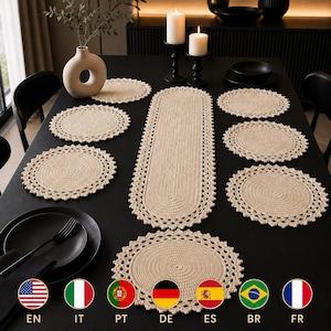 Puede incluir: Un juego de mantelería de ganchillo en color beige que consta de un camino de mesa ovalado largo y seis manteles individuales circulares. Cada pieza presenta un centro tejido apretado con un borde decorativo festoneado sobre una superficie oscura.