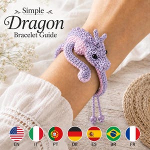 May include: A crocheted dragon bracelet in lavender and light pink yarn with black bead eyes. The bracelet features a coiled dragon design that wraps around the wrist, ending in two dangling lavender beads. Text reads: Simple Dragon Bracelet Guide.
