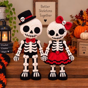 Op de afbeelding: Twee gehaakte skeletpoppen. De linkerpop draagt een zwarte hoge hoed met een rode band en een kleine schedel, en een rode vlinderdas. De rechterpop draagt een rode haarstrik met een kleine schedel en een rode rok met een hartje erop.