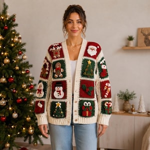 May include: A cream-colored V-neck cardigan constructed from crocheted squares featuring festive Christmas motifs including Santa Claus, a snowman, gingerbread men, reindeer, decorated pine trees, candy canes, stockings, and wrapped gifts.