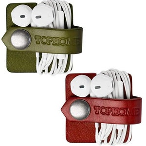 May include: Two leather headphone holders, one in olive green and one in burgundy red. Both holders feature a white cord wrap and white earbuds. The holders have the text "TOPHOME" embossed on the front.