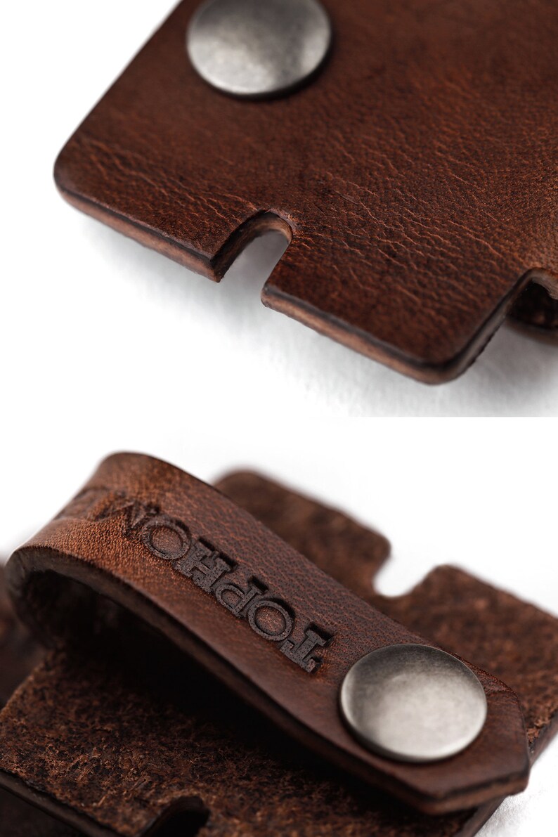 May include: A brown leather strap with a silver metal button and the word "Topol" embossed on it.