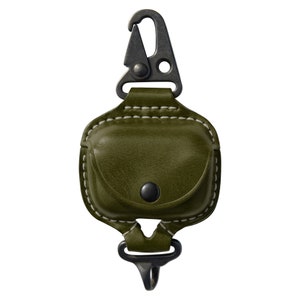 Op de afbeelding: Een groene leren hoes met een metalen clip om AirPods of andere kleine voorwerpen te dragen.