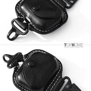 Op de afbeelding: Zwart leren etui met witte stiksels en een zwarte metalen karabijnhaak. Het etui heeft een klep die met een knoop kan worden gesloten. De tekst "TOPHOME Simple Design Simple Life" staat onderaan de afbeelding.