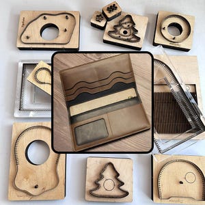 Puede incluir: Una colección de herramientas de artesanía en cuero y una cartera de cuero marrón. Las herramientas incluyen varias matrices de madera y metal en diferentes formas, incluyendo un árbol, un círculo y formas irregulares. La cartera está abierta, revelando múltiples compartimentos.