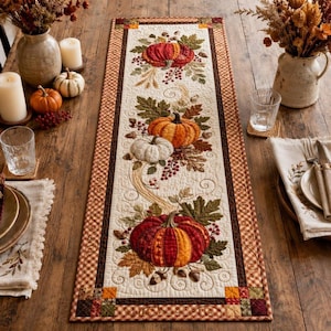 May include: A rectangular quilted table runner featuring a cream-coloured centre panel decorated with appliqued pumpkins in shades of red, orange, and white, surrounded by autumn leaves, berries, and vines, framed by a brown and tan checkered border.