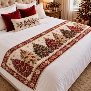 May include: A cream-coloured bed runner featuring a repeating pattern of embroidered Christmas trees in shades of green, red, and gold, accented with small stars and a decorative border of red fabric with gold leaf and white poinsettia motifs.