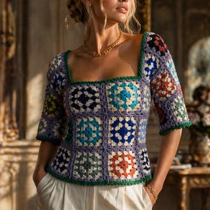 Könnte beinhalten: Buntes Häkeltop mit quadratischem Ausschnitt und kurzen Ärmeln. Das Oberteil hat ein Patchwork-Design mit blauen, grünen, orangefarbenen und weißen Quadraten. Es wird mit einer weißen Bundfaltenhose getragen. Eine goldene Halskette und ein Armband vervollständigen den Look.