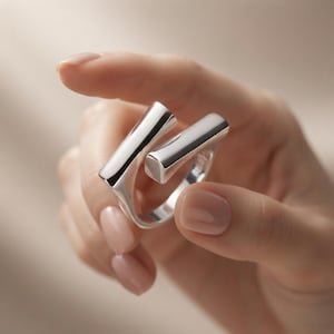 Op de afbeelding: Een gepolijste zilveren ring met een open ontwerp, bestaande uit twee gladde, rechthoekige staven die elkaar niet raken. Het metaal heeft een reflecterende, hoogglanzende afwerking en de ring is gemaakt uit één doorlopend zilverkleurig stuk.