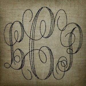 May include: A burlap pillow with a black embroidered monogram of the letters "LHP".