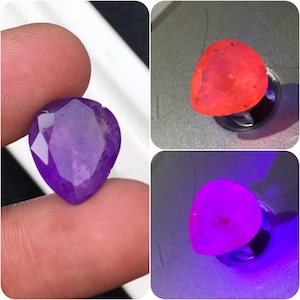 May include: A pear-shaped faceted gemstone shown in three different lighting conditions. The stone appears deep purple in natural light, glows a vibrant orange under one light source, and emits a bright neon purple hue under ultraviolet light.