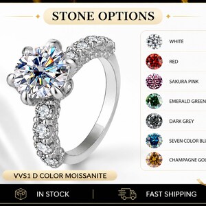 May include: A silver-toned ring featuring a large round-cut center stone and smaller stones along the band. The text reads STONE OPTIONS, VVS1 D COLOR MOISSANITE, WHITE, RED, SAKURA PINK, EMERALD GREEN, DARK GREY, SEVEN COLOR BLUE, and CHAMPAGNE GOLD.