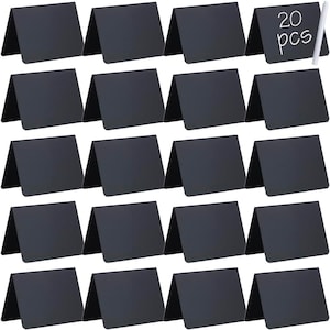 May include: A set of 20 black rectangular chalkboard signs, each folded into a tent shape for standing. The top right sign features the white text 20 pcs, and a single white chalk stick is positioned vertically next to it for writing.