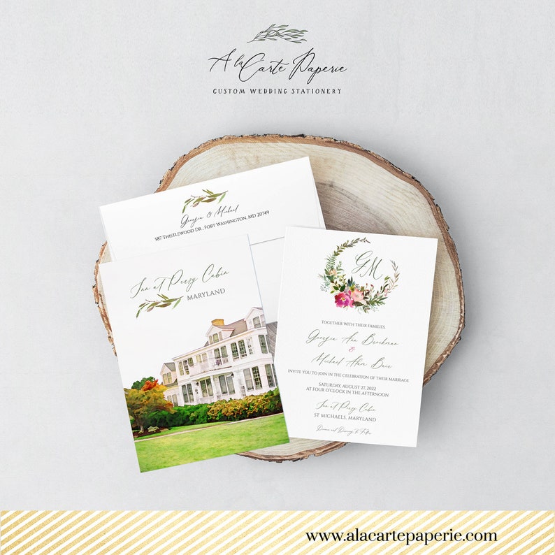 May include: Wedding stationery set featuring a watercolor illustration of a house, floral wreath, and elegant script. The set includes an invitation, RSVP card, and envelope, all on a wooden slice. The website address www.alacartepaperie.com is visible.
