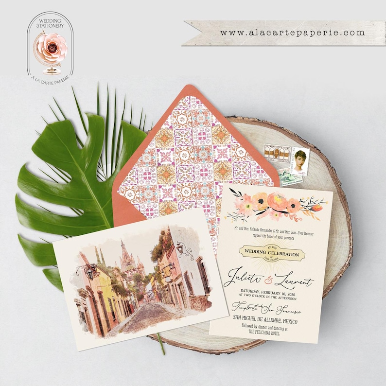 Puede incluir: Juego de papeler&iacute;a de boda con una escena callejera en acuarela, invitaci&oacute;n y sobre estampado. La invitaci&oacute;n incluye detalles florales y los nombres "Juliet & Laurent". La direcci&oacute;n del sitio web "www.alacartepaperie.com" es visible.