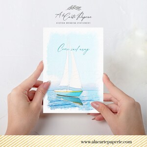 May include: A watercolor illustration of a sailboat on a greeting card. The boat is turquoise with a white sail, sailing on blue water. The card has the text "Come sail away" in teal script. The card is held by two hands.