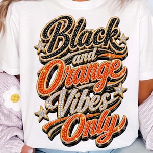 Może przedstawiać: Biały t-shirt z grafiką zawierającą napis Black and Orange Vibes Only. Litery są wykonane w stylu 3D w kolorach czarnym i pomarańczowym, ozdobione małymi białymi kropkami przypominającymi cyrkonie oraz kilkoma małymi gwiazdkami.