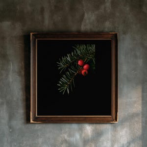 May include: A square wall art piece featuring a dark brown wooden frame. Inside the frame is a black background with a single green pine branch extending from the top right corner, adorned with three small, round, bright red berries.