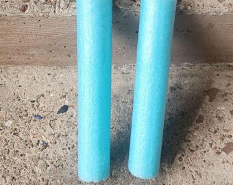 May include: A pair of light blue foam cylinders connected by a black plastic chain. The two cylindrical foam pieces are joined at the top by black plastic caps and a short, flexible black plastic link, forming a nunchaku-style object.