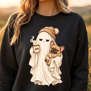 Peut inclure: Un sweat-shirt noir à col rond arborant un motif de fantôme blanc portant un bonnet beige, tenant une tasse fumante avec l'inscription MEH et portant un bouledogue français beige. Le fantôme et le chien ont des expressions faciales assorties.