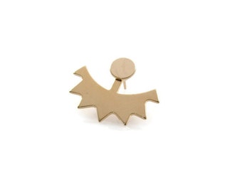 May include: Gold-toned ear cuff with a starburst design. The cuff is curved and has a small round disc at the top.