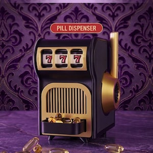 May include: A black and gold pill dispenser shaped like a slot machine with the text Pill-O-Matic and PILL DISPENSER. The device features three spinning reels displaying the number seven and a small tray at the bottom containing yellow capsules.