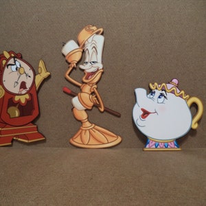 May include: Four characters from the Disney film Beauty and the Beast. The characters are a red clock, a yellow candlestick, a white teapot, and a white teacup. The characters are all smiling and have painted details.