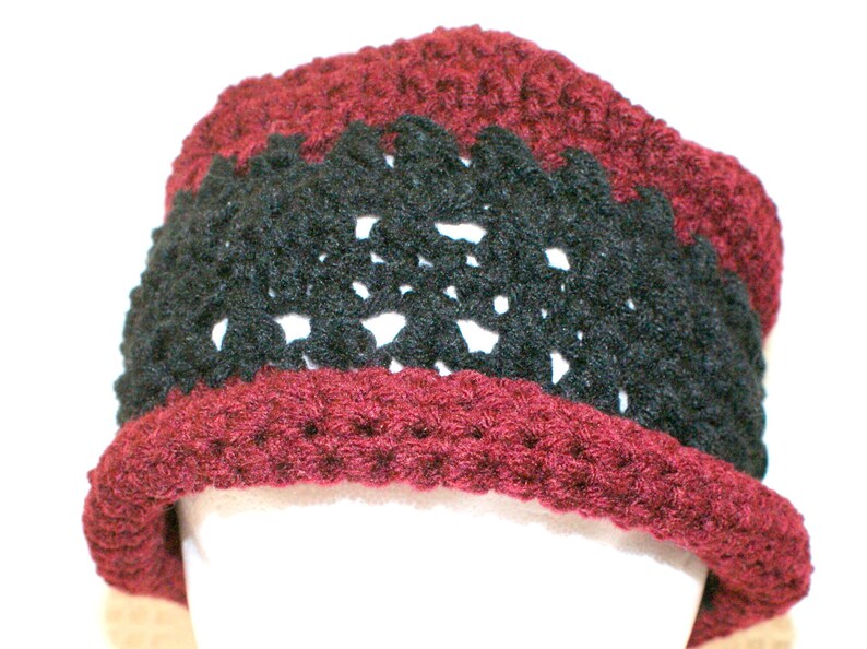 May include: A burgundy crocheted hat with a black crocheted band.