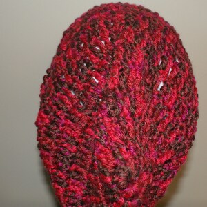 May include: A red and brown knitted hat with a textured pattern.