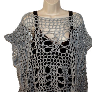 May include: Gray crochet top with a loose, open-weave design. The top has a wide, round neckline and short, flared sleeves.