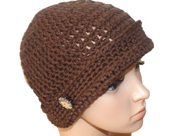 May include: A brown crocheted beanie with a wide brim and a decorative button. The beanie is made with a simple stitch pattern and has a slouchy fit.