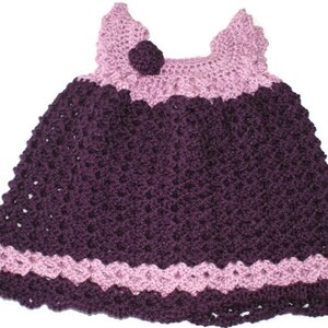 May include: A crocheted baby dress with a purple bodice and pink straps and trim.
