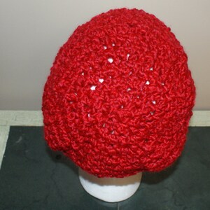 May include: A red crocheted beanie hat with a textured stitch pattern.