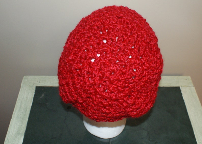 May include: A red crocheted beanie hat with a textured stitch pattern.