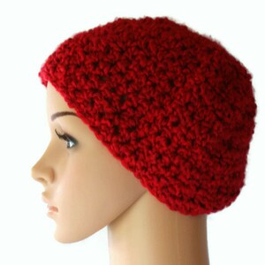 May include: A red crocheted beanie hat. The hat is made with a textured stitch and has a simple, classic design.