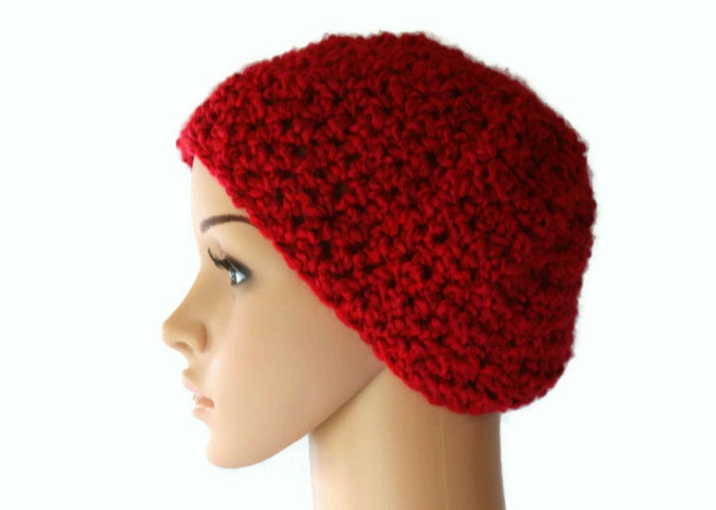 May include: A red crocheted beanie hat. The hat is made with a textured stitch and has a simple, classic design.