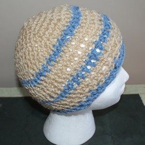 May include: A beige crocheted beanie with blue stripes. The beanie is on a white mannequin head.