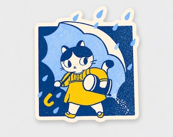 May include: A square sticker featuring a white cat with dark blue hair wearing a yellow dress. The cat holds a yellow-handled blue umbrella while walking in the rain. The background is a dark blue square with light blue raindrops falling.