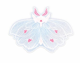 May include: A die-cut sticker featuring a stylized moth with light blue wings, white wing veins, and pink heart-shaped accents. The moth has a fluffy white body and pink feathery antennae, all outlined with a thin white border on a plain background.