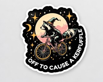 May include: A die-cut sticker featuring a raccoon wearing a pointed hat, riding a bicycle in front of a large moon. The background is black with yellow stars and a crescent moon. The text reads, OFF TO CAUSE A KERFUFFLE in white capital letters.