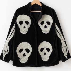 May include: A black velvet jacket featuring four large, embroidered off-white skull motifs on the front panels. The sleeves are decorated with long, embroidered off-white skeletal arm and hand designs that extend from the shoulders to the cuffs.